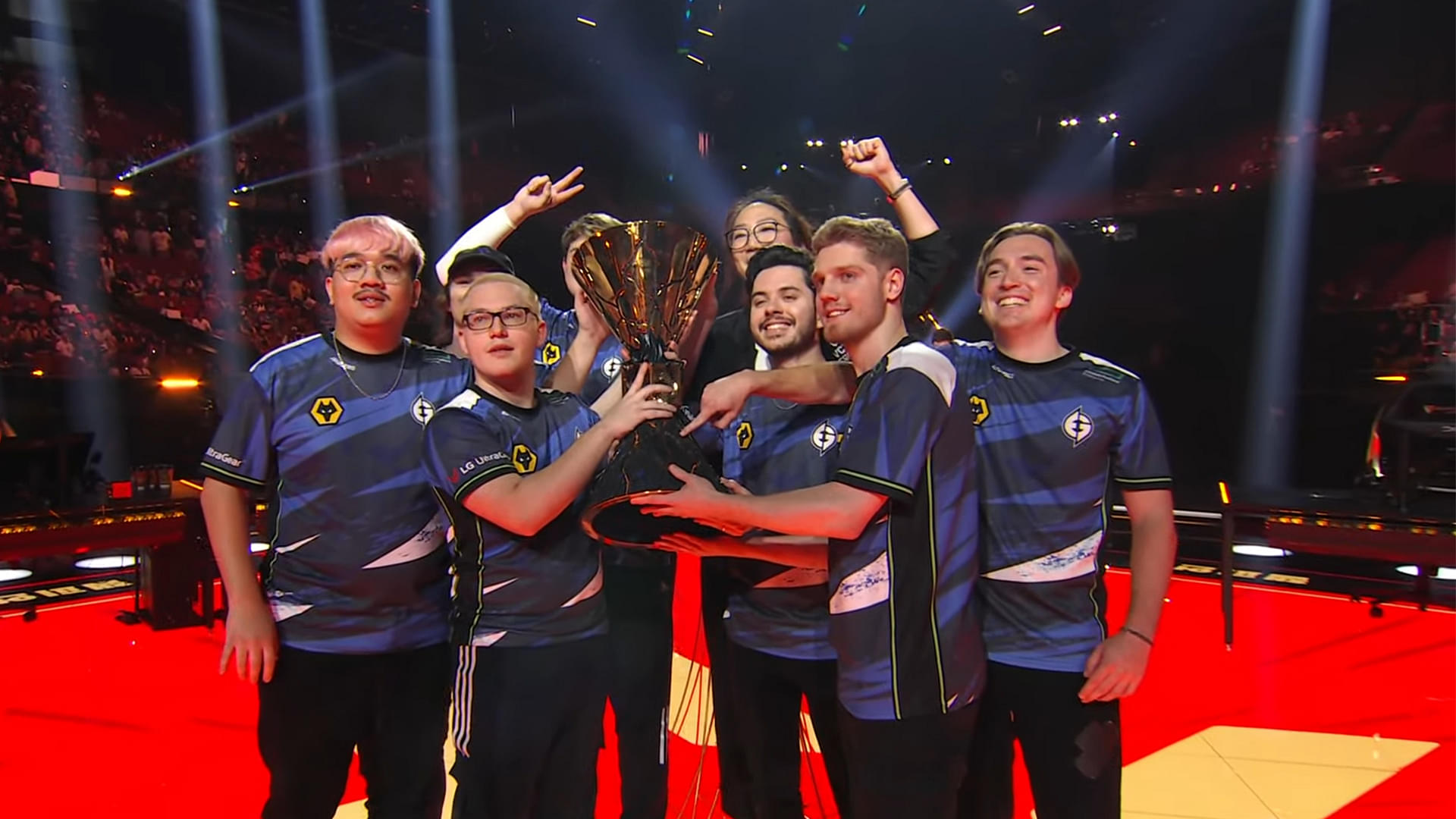 An image showing Evil Geniuses team memebers holding Valorant Champions 2023 trophy with their coach