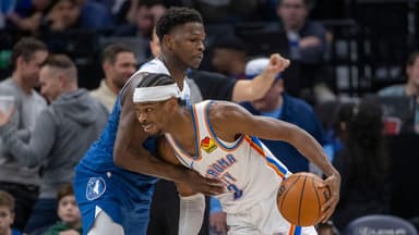 Oklahoma City Thunder guard Shai Gilgeous-Alexander (2) dribbles the ball past Minnesota Timberwolves guard Anthony Edwards (5) in the second half at Target Center.