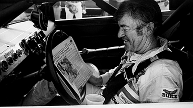 The defending Winston Cup points champion Bobby Allison checks out the newspaper during qualifying trials for the Nashville Pepsi 420 NASCAR Grand National race at Nashville International Raceway on July 13, 1984