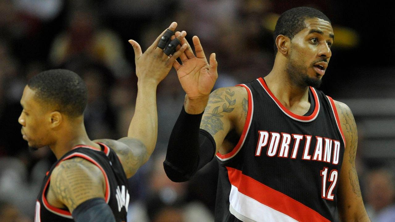 Jan 28, 2015; Cleveland, OH, USA; Portland Trail Blazers forward LaMarcus Aldridge (12) celebrates with guard Damian Lillard (0) in the third quarter against the Cleveland Cavaliers at Quicken Loans Arena.