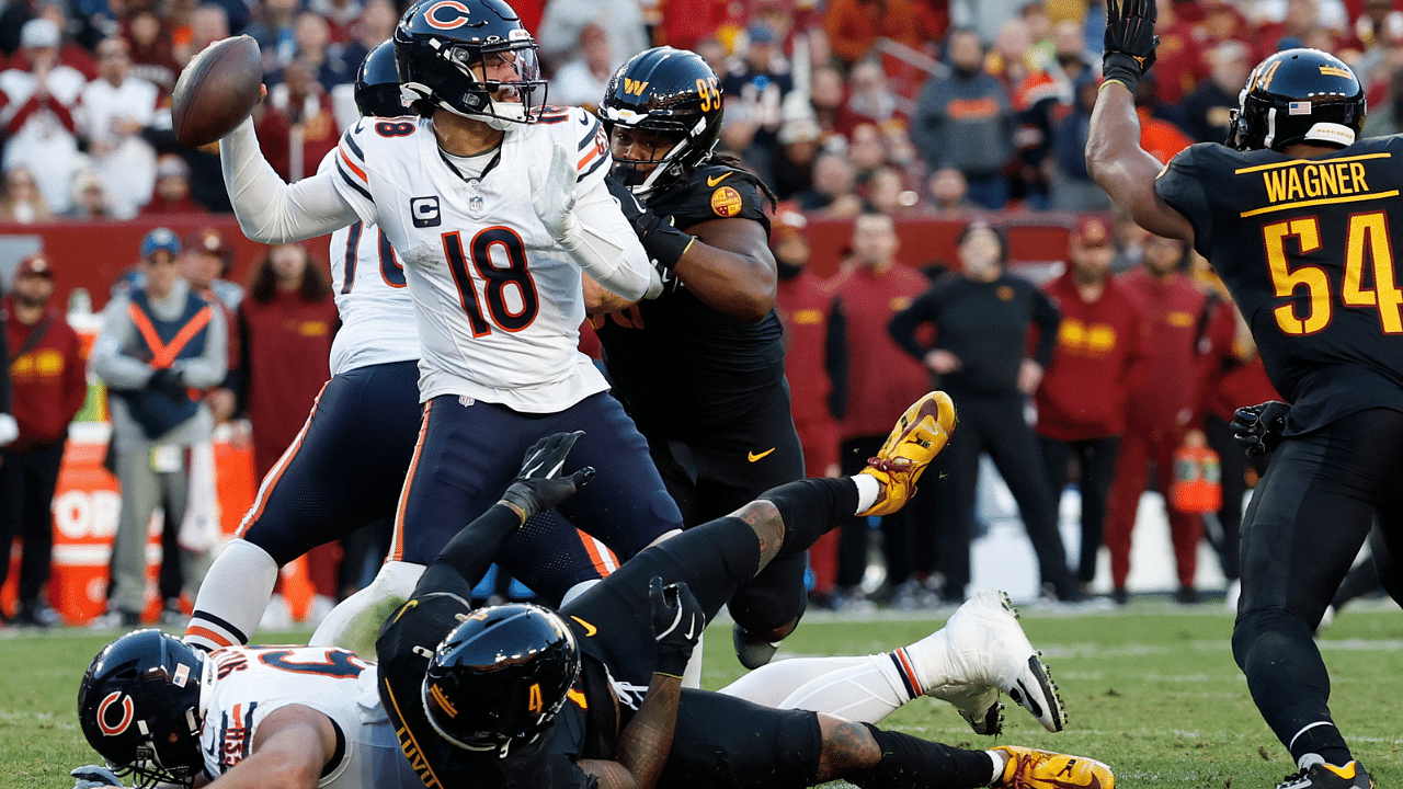 Chicago Bears quarterback Caleb Williams (18) passes the ball as Washington Commanders linebacker Frankie Luvu (4) and Commanders linebacker Bobby Wagner (54) defend during the second quarter at Northwest Stadium.