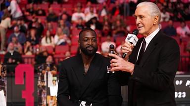 Miami Heat president Pat Riley (R) shows former player Dwayne Wade (L) a bobble head while announcing that a statue in the likeness of Wade will be erected outside the arena in 2025, during halftime of the game between the Miami Heat and the Charlotte Hornets at Kaseya Center.