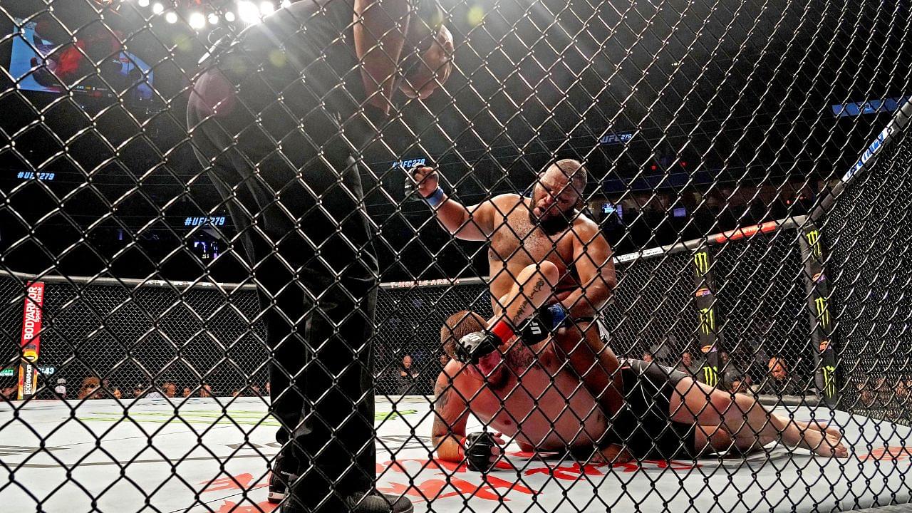 Jake Collier (red gloves) fights Chris Barnett (blue gloves) during UFC 279 at T-Mobile Arena.