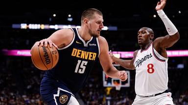 Denver Nuggets center Nikola Jokic (15) controls the ball as Los Angeles Clippers guard Kris Dunn (8) guards in the fourth quarter at Ball Arena.