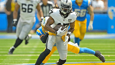 Las Vegas Raiders wide receiver Davante Adams (17) is stopped by Los Angeles Chargers safety Alohi Gilman (32) after a compete pass in the first half at SoFi Stadium.