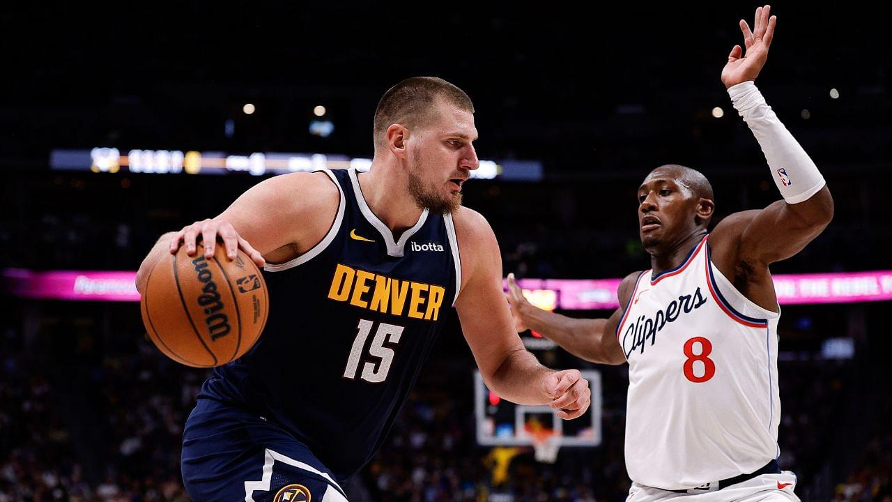 Denver Nuggets center Nikola Jokic (15) controls the ball as Los Angeles Clippers guard Kris Dunn (8) guards in the fourth quarter at Ball Arena.