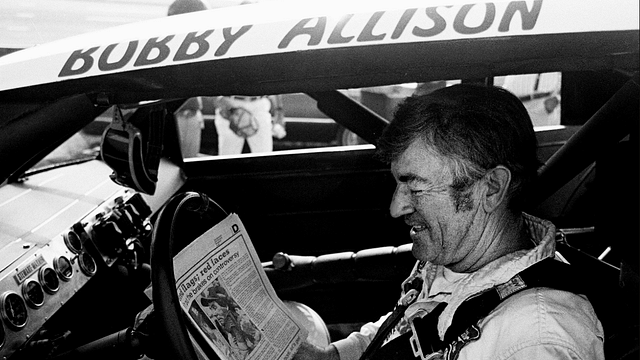 The defending Winston Cup points champion Bobby Allison checks out the newspaper during qualifying trials for the Nashville Pepsi 420 NASCAR Grand National race at Nashville International Raceway on July 13, 1984