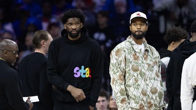 Injured Philadelphia 76ers Paul George (R) and Joel Embiid (L) look on during the first quarter against the Memphis Grizzlies at Wells Fargo Center.