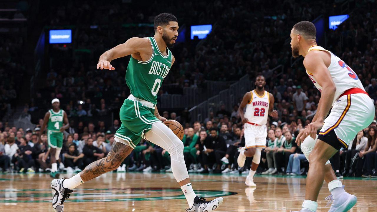 Boston Celtics forward Jayson Tatum (0) drives to the basket during the first half defended by Golden State Warriors guard Stephen Curry (30) at TD Garden.