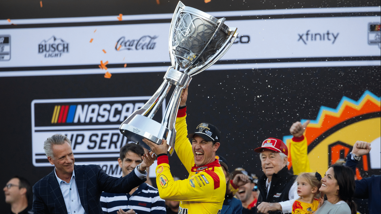 NASCAR Cup Series driver Joey Logano (right) is presented the Bill France Trophy by NASCAR president Steve Phelps after winning the 2024 NASCAR Cup Series championship and the NASCAR Cup Series Championship race at Phoenix Raceway.