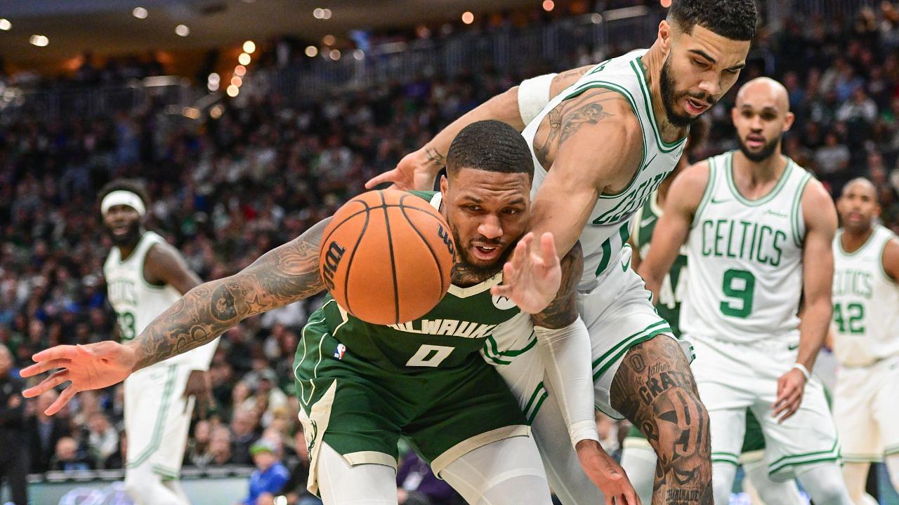 Milwaukee Bucks guard Damian Lillard (0) and Boston Celtics forward Jayson Tatum (0) reach for a loose ball in the second quarter at Fiserv Forum.