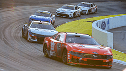 Cars leave turn two as the sun starts to set during the Xfinity 500 at Martinsville Speedway.