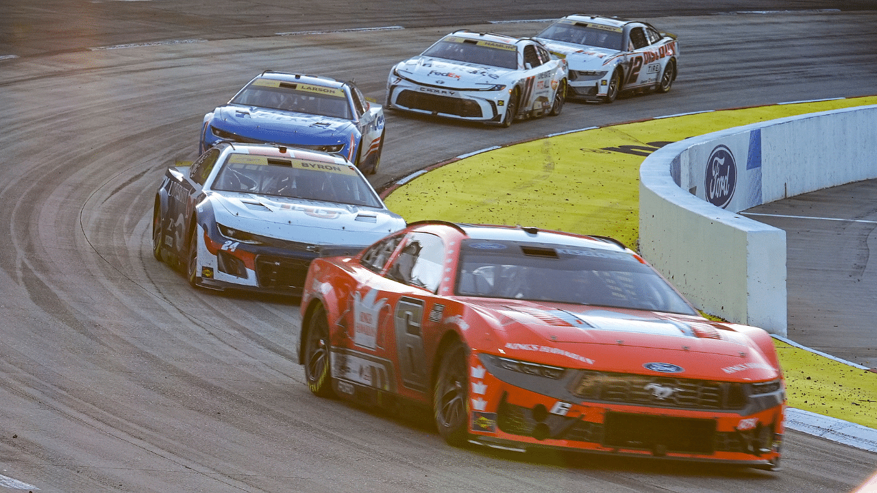 Cars leave turn two as the sun starts to set during the Xfinity 500 at Martinsville Speedway.