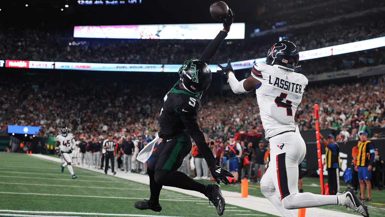 New York Jets wide receiver Garrett Wilson (5) catches a touchdown pass while being defended by Houston Texans cornerback Kamari Lassiter (4) during the second half at MetLife Stadium.