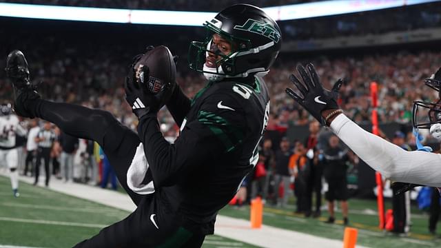 Oct 31, 2024; East Rutherford, New Jersey, USA; New York Jets wide receiver Garrett Wilson (5) catches a touchdown pass while being defended by Houston Texans cornerback Kamari Lassiter (4) during the second half at MetLife Stadium.