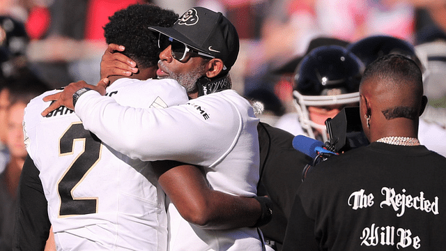 Colorado football coach Deion Sanders hugs his son, Shedeur Sanders, before facing Texas Tech in a Big 12 football game