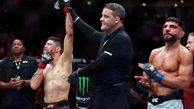 Brandon Moreno (red gloves) celebrates after defeating Amir Albazi (blue gloves) in a flyweight bout during UFC Fight Night at Rogers Place.