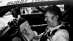 The defending Winston Cup points champion Bobby Allison checks out the newspaper during qualifying trials for the Nashville Pepsi 420 NASCAR Grand National race at Nashville International Raceway on July 13, 1984