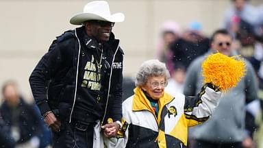 Colorado Buffaloes head coach holds the hand of fan Peggy Coppom before the start of the spring game at Folsom Filed.