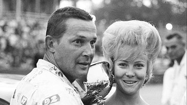 Driver Jim Paschal, left, accepts the trophy from Jenny Smith, Miss Fairgrounds Speedway, after winning the Nashville 400 at the Fairgrounds Speedway Aug. 4, 1963. Paschal won his third straight on the track in the rain-shortened NASCAR late model race before 12,875 fans. Auto Racingt In 1963