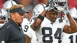 Oakland Raiders wide receiver Antonio Brown (84) puts on bis football helmet alongside head coach Jon Gruden against the Arizona Cardinals during a preseason game at State Farm Stadium.