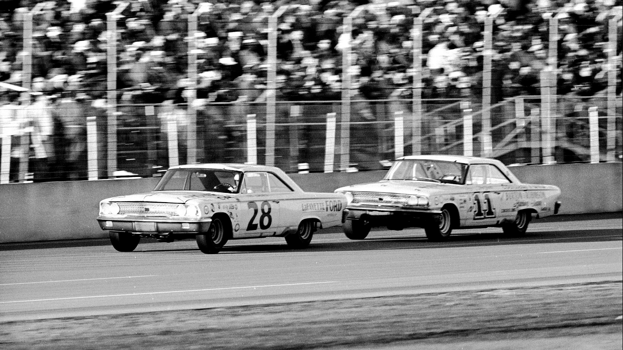 DAYTONA BEACH - FEBRUARY 24: Cars race past the grandstands during the Daytona 500, Daytona Beach, Florida, February 24, 1963. American driver Fred Lorenzen is in car #28, while Ned Jarrett drives #11. Michael Rougier/The LIFE Picture Collection