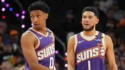 Phoenix Suns forward Ryan Dunn (0) and Phoenix Suns guard Devin Booker (1) look on against the Miami Heat during the first half at Footprint Center.