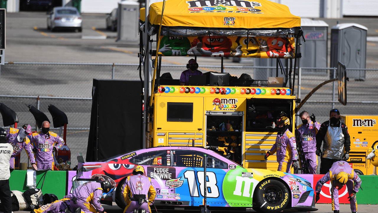 Crews for Monster Energy NASCAR Cup Series driver Kyle Busch (18) put additional work into the right rear on a stop during the Quaker State 400 at Kentucky Speedway.