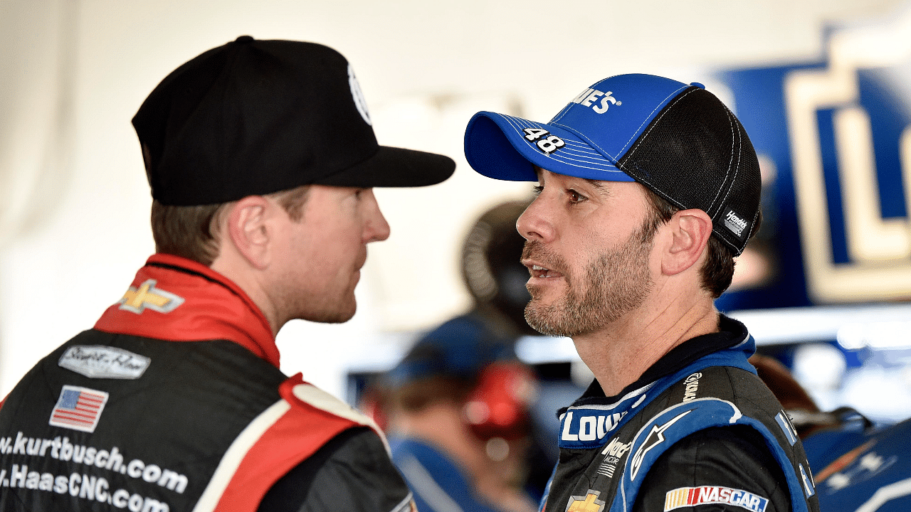 NASCAR Sprint Cup Series driver Jimmie Johnson (right) talks with Kurt Busch during practice for the Ford EcoBoost 400 at Homestead-Miami Speedway.