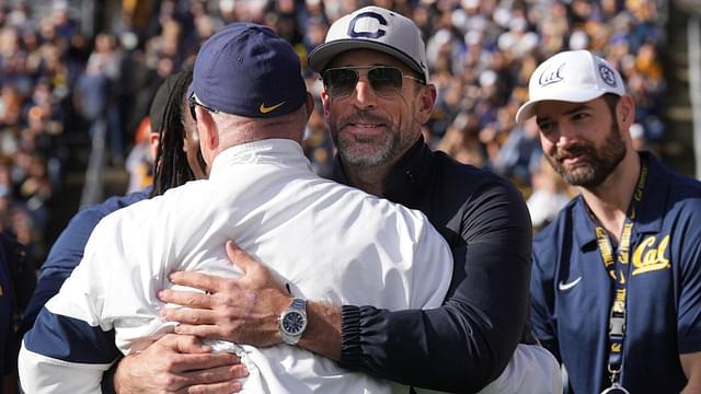 California Golden Bears former quarterback Aaron Rodgers (center right) hugs former head coach Jeff Tedford (left) before the start of the second quarter against the Stanford Cardinal at California Memorial Stadium.