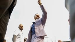 MMA fighter Conor McGregor waves to fans as he walks on the field before the game between the Chicago Cubs and the Minnesota Twins at Wrigley Field.