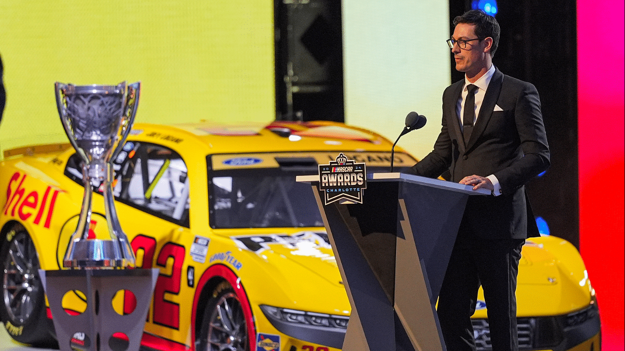 NASCAR Cup Series driver Joey Logano (22) next to his car and trophy talks to the audience after being announced as the three time Cup champion during the NASCAR Awards Banquet at Charlotte Convention Center.