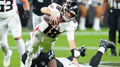 Dec 16, 2024; Paradise, Nevada, USA; Atlanta Falcons quarterback Kirk Cousins (18) is tripped up by Las Vegas Raiders defensive tackle Jonah Laulu (96) during the second quarter at Allegiant Stadium.