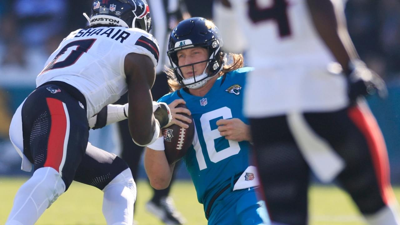 Jacksonville Jaguars quarterback Trevor Lawrence (16) slides for a down as Houston Texans linebacker Azeez Al-Shaair (0) makes a late hit during the second quarter of an NFL football matchup Sunday, Dec. 1, 2024 at EverBank Stadium in Jacksonville, Fla.