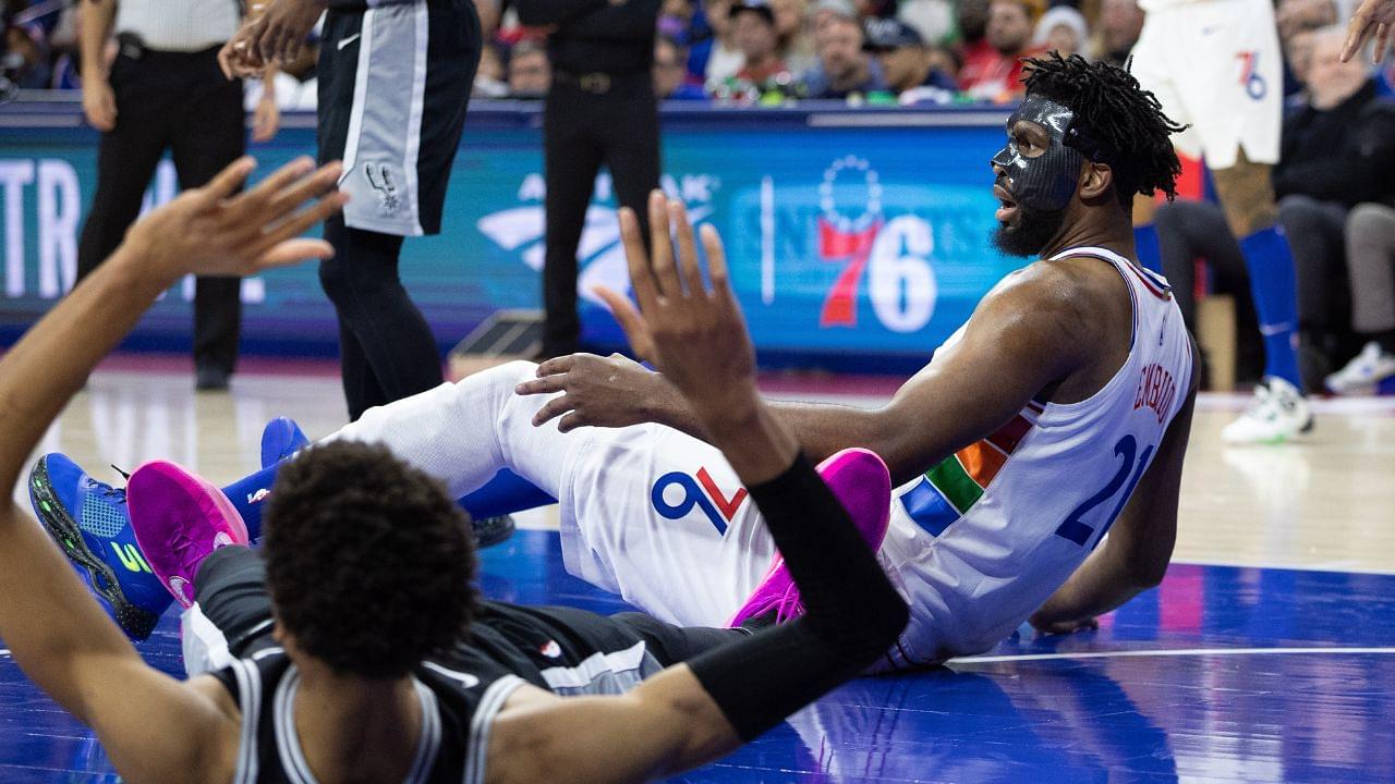 Philadelphia 76ers center Joel Embiid (21) and San Antonio Spurs center Victor Wembanyama (1) fall to the floor after colliding during the second quarter at Wells Fargo Center.