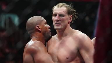 Ciryl Gane (red gloves) hugs Alexander Volkov (blues gloves) after their fight at T-Mobile Arena.