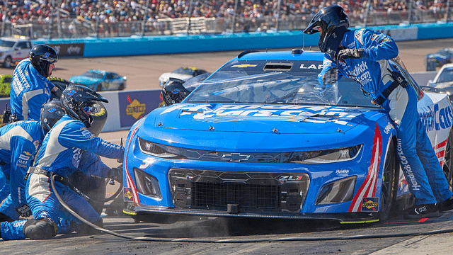 The pit crew of NASCAR Cup Series driver Kyle Larson (5) work to change the tires and remove a tear-off from the windshield during the United Rentals Work United 500 at Phoenix Raceway in Avondale on March 12, 2023.