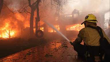 January 8, 2025, Los Angeles, California, USA: A firefighter battles a home in flames in Pacific Palisades during the second day of the Palisades fire which has burned more than 15,000 acres and destroyed at least 1,000 structures Los Angeles USA - ZUMAa01_ 20250108_zaf_a01_003 Copyright: xJonathanxAlcornx