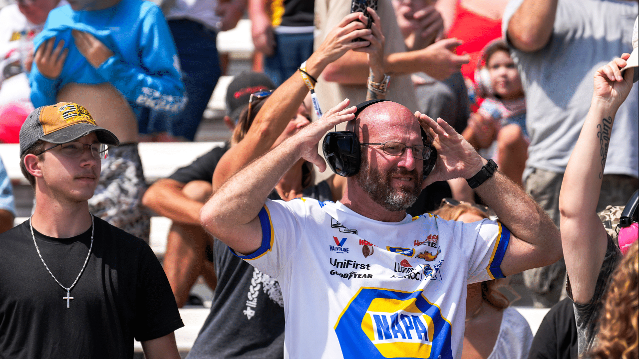 Sep 8, 2024; Hampton, Georgia, USA; Fans prepare for the race by putting on ear muffs to deaden the sound of the cars at Atlanta Motor Speedway. Mandatory Credit: Jason Allen-Imagn Images