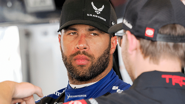 NASCAR Cup Series driver Bubba Wallace (23) talks in his garage Friday, July 19, 2024, during practice for the Brickyard 400 at Indianapolis Motor Speedway.