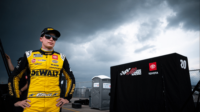 NASCAR Cup Series driver Christopher Bell stands with his crew after exiting his car due to a lightning delay during the Ally 400 at Nashville Superspeedway in Lebanon, Tenn., Sunday, June 30, 2024.