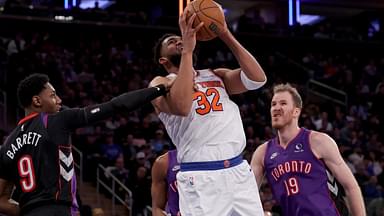 New York Knicks center Karl-Anthony Towns (32) is fouled by Toronto Raptors guard RJ Barrett (9) as he drives to the basket against Raptors center Jakob Poeltl (19) during the third quarter at Madison Square Garden.