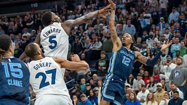 Memphis Grizzlies guard Ja Morant (12) falls back after releasing the game winning shot over Minnesota Timberwolves guard Anthony Edwards (5) in the second half at Target Center.