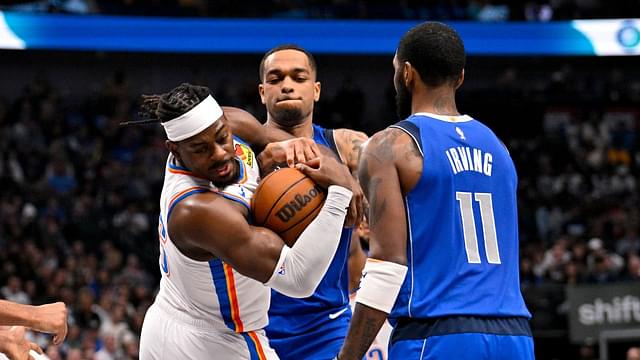 Oklahoma City Thunder guard Luguentz Dort (5) takes the ball away from Dallas Mavericks forward P.J. Washington (25) as guard Kyrie Irving (11) looks on during the second quarter at the American Airlines Center.