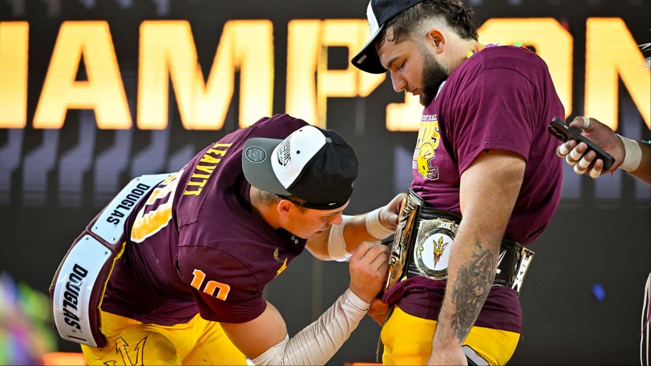 Arizona State Sun Devils quarterback Sam Leavitt (10) signs the WWE Big 12 championship belt of running back Cam Skattebo (4) celebrates after the Sun Devils defeat the Iowa State Cyclones and win the 2024 Big 12 Championship at AT&T Stadium.