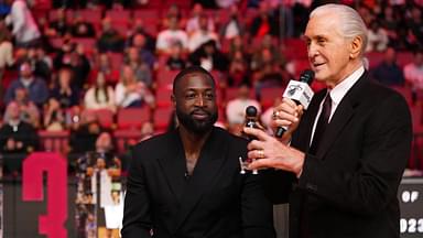 Miami Heat president Pat Riley (R) shows former player Dwayne Wade (L) a bobble head while announcing that a statue in the likeness of Wade will be erected outside the arena in 2025, during halftime of the game between the Miami Heat and the Charlotte Hornets at Kaseya Center