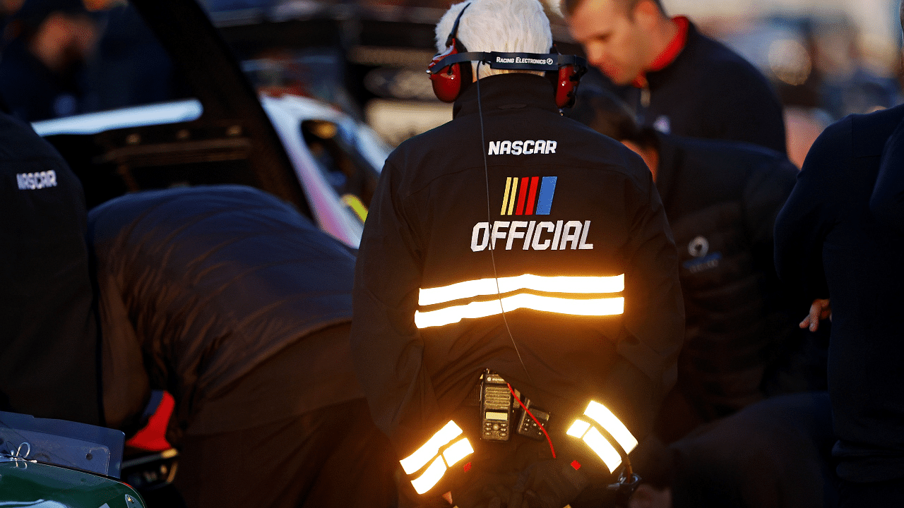 A NASCAR official watches on as team make adjust to their cars before the last change qualifying race for the Clash at Bowman Gray at Bowman Gray Stadium.