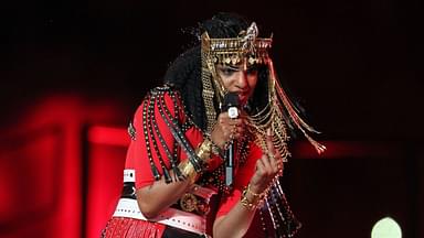 Recording artist MIA gestures towards the camera during the halftime show for Super Bowl XLVI between the New York Giants and New England Patriots at Lucas Oil Stadium.