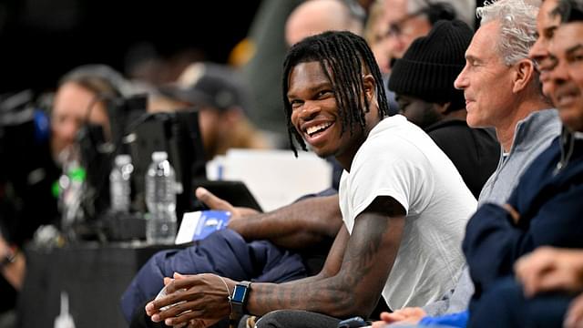 Heisman Trophy winner Travis Hunter Jr. laughs during the second half of the game between the Dallas Mavericks and the Minnesota Timberwolves at the American Airlines Center.