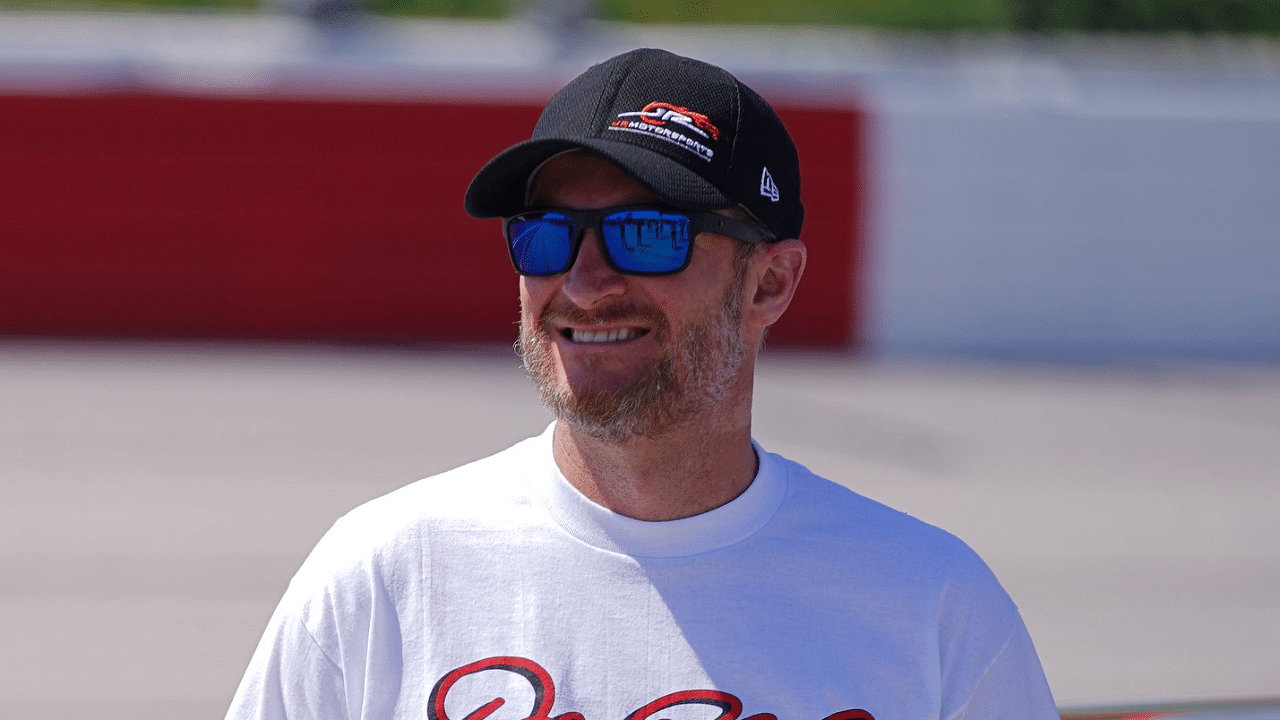 Former NASCAR driver Dale Earnhardt Jr. poses for a picture with the restored 1984 Chevy Nova driven by his father the late Dale Earnhardt Sr. on pit road prior to the Steakhouse Elite 200 at Darlington Raceway.